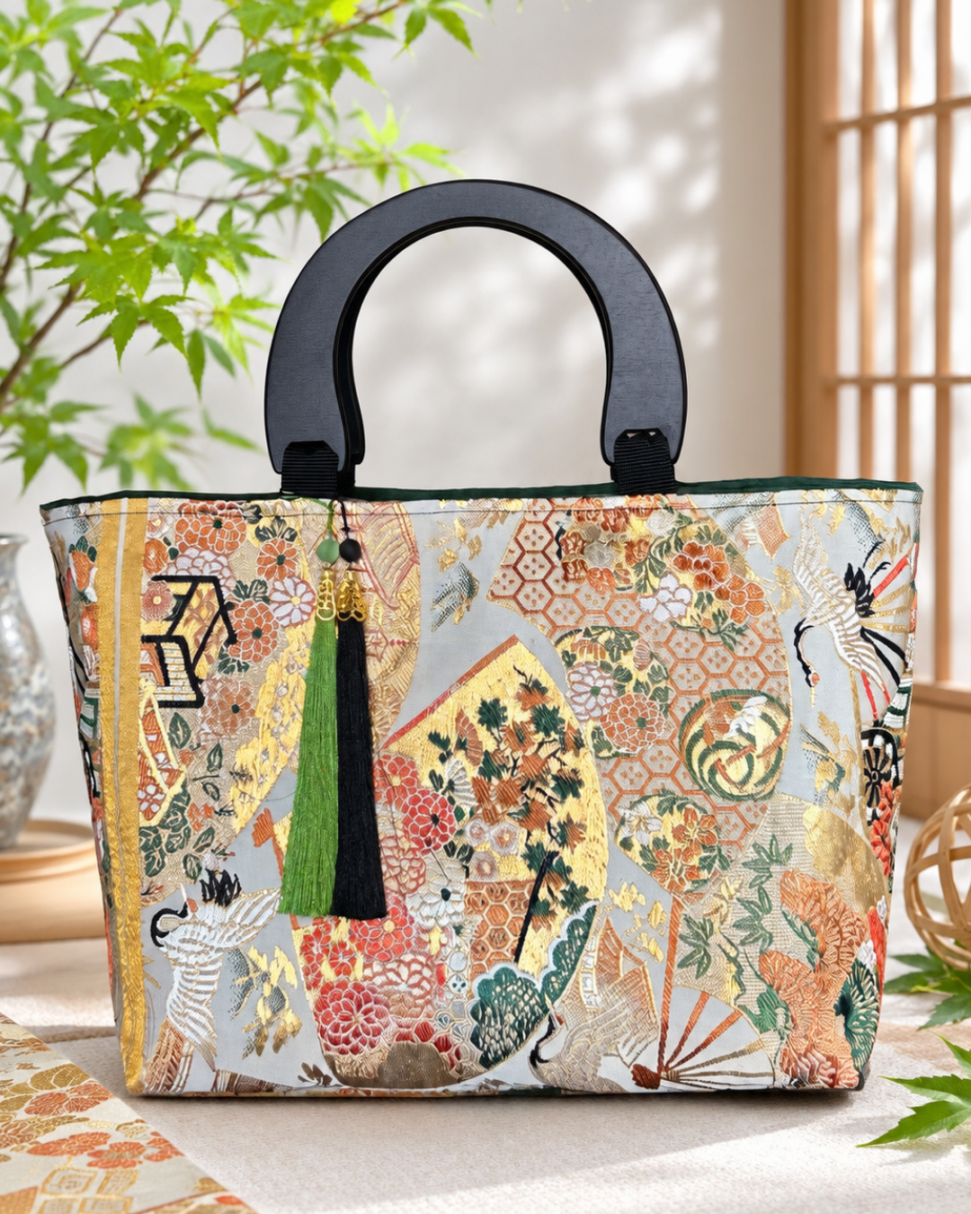 鶴や花の華やかな和柄に黒い持ち手を合わせた帯バッグ